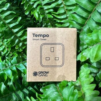 Smart timer box among green ferns for eco-friendly gardening automation.
