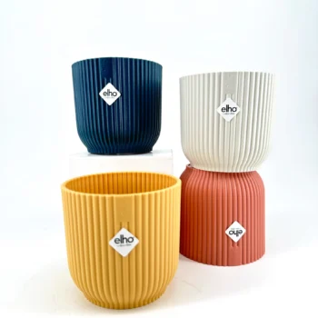 Eco-friendly elho ribbed decorative plant pots in navy, creamy white, mustard yellow, and coral.
