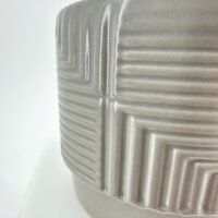 Modern grey ceramic pot with textured geometric patterns, set against a white background.