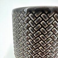 Textured ceramic planter with geometric pattern, glossy dark finish, modern home decor.