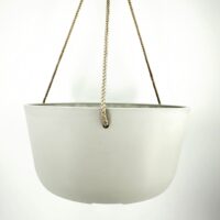 Modern minimalist hanging planter with glossy white ceramic body and gold-toned braided ropes.